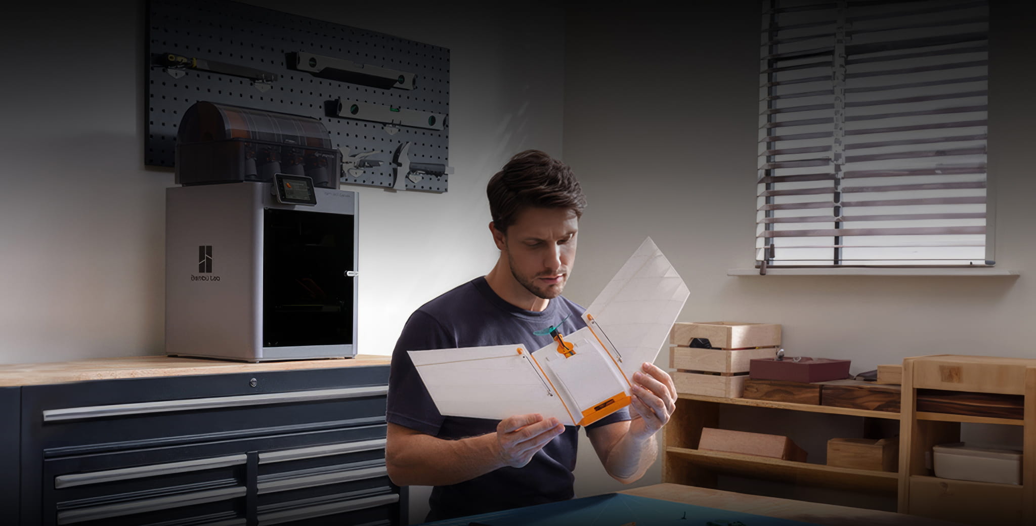 Maker inspecting transparent 3D printed part in home workshop with Bambu Lab printer